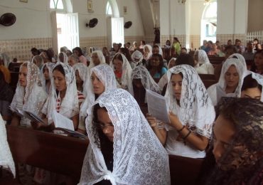 Padre sobre a roupa das mulheres na igreja