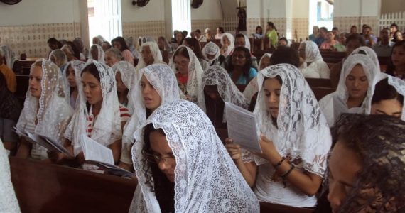 Padre sobre a roupa das mulheres na igreja