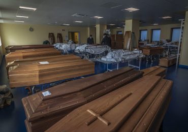 Funcionários de uma funerária preparam caixões em Bérgamo.